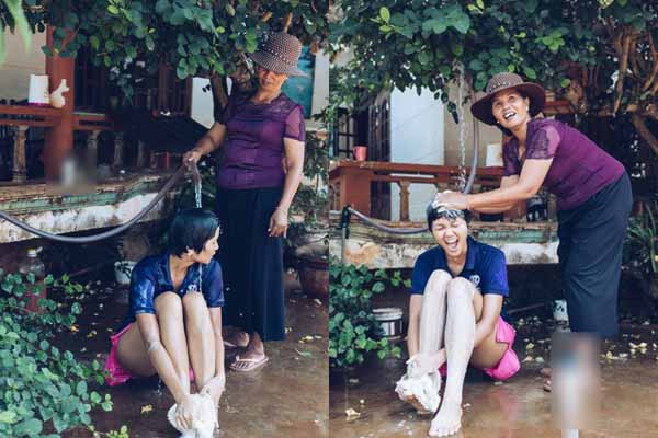 Mẹ xịt nước tắm cho H’Hen Niê ở hiên nhà